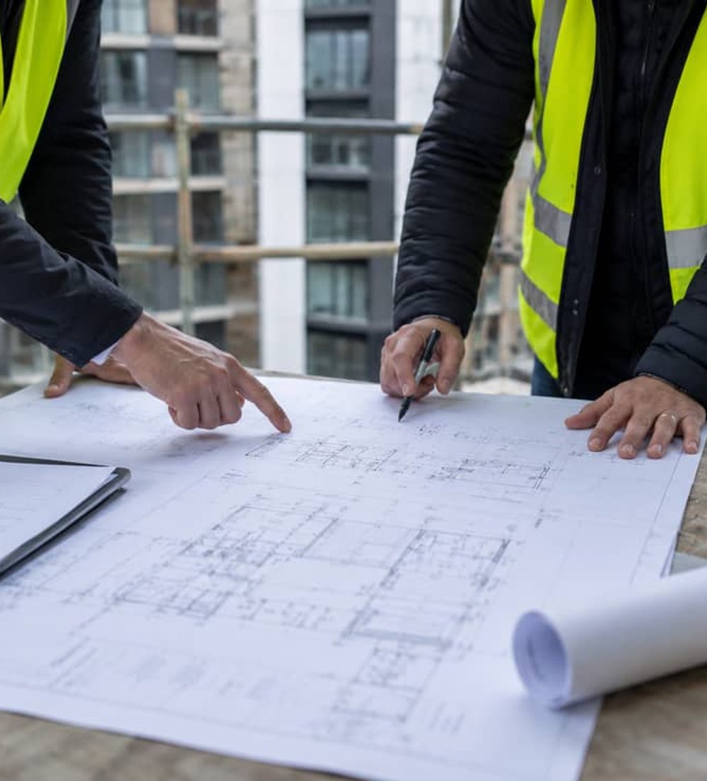 Building consultant reviewing plans on site